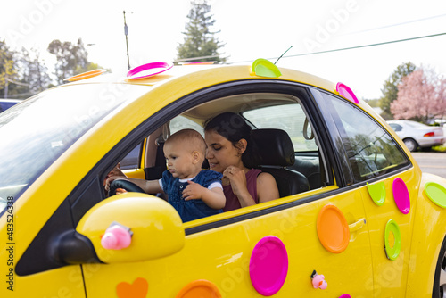Happy mother and her adorable baby in colorful slug bug decorated for easter photo
