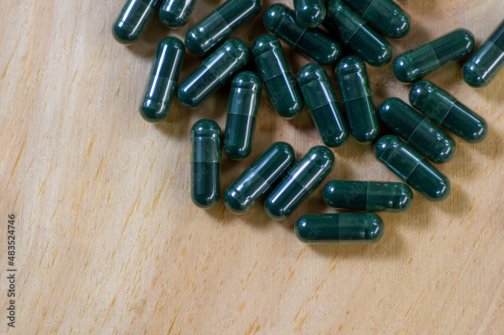 Close up of green medicine capsules, Spirulina, in shallow focus Close up of green medicine capsules, Spirulina, in shallow focus