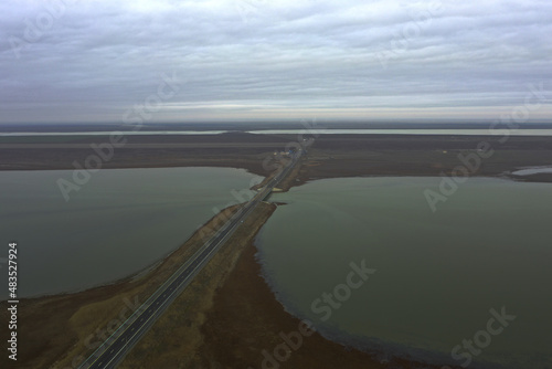 asphalt road and bridge over a lake in the steppe photo from a quadcopter landscape