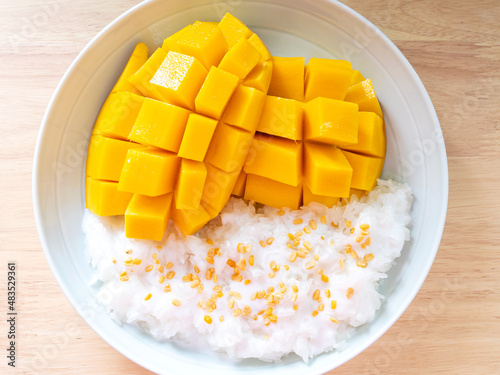 Close up of mango sticky rice with coconut milk on plate. Thai dessert with selective focus