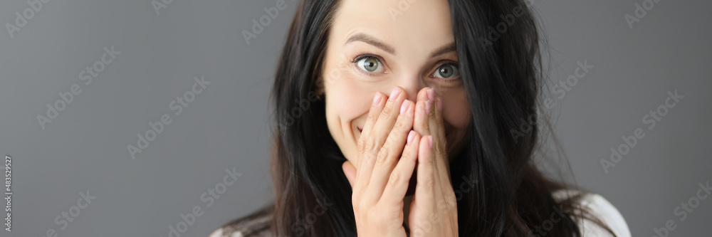 Portrait of smiling young woman covering nose with hand Portrait of smiling young woman covering nose with hand