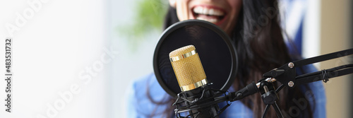 Studio black microphone in background woman sings closeup