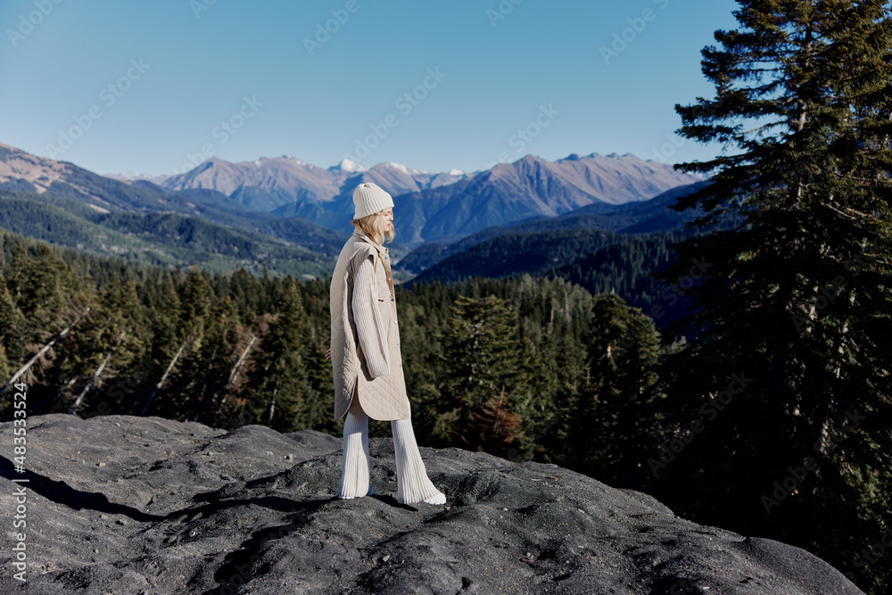 woman in autumn clothes stands on a rock landscape blue sky relaxation woman in autumn clothes stands on a rock landscape blue sky relaxation