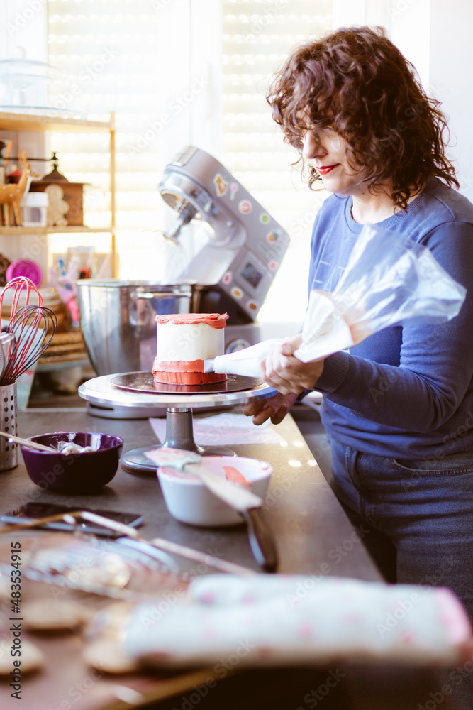 Caucasian woman carefully preparing a cake. Pastry at home. Selective focus. Caucasian woman carefully preparing a cake. Pastry at home. Selective focus.