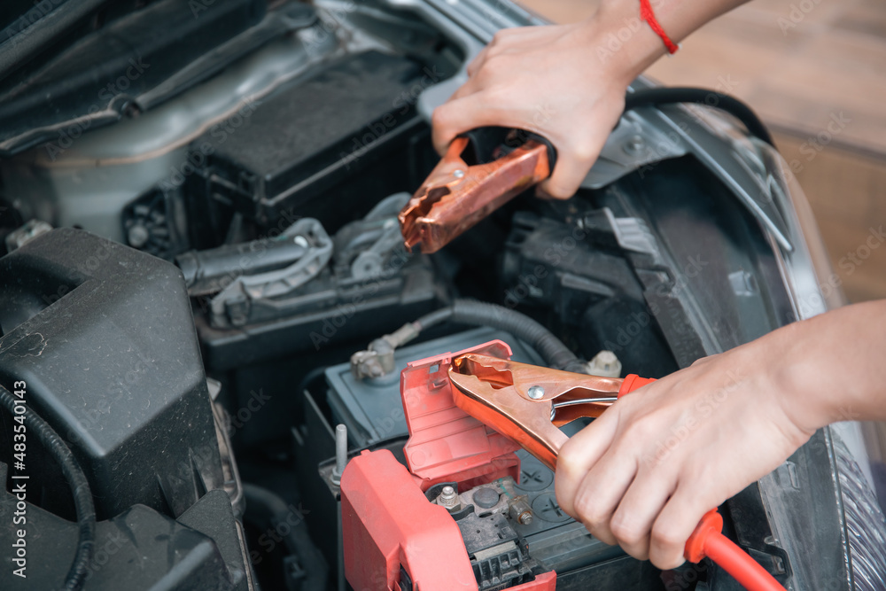 Woman trying to jumping a vehicle battery. Woman trying to jumping a vehicle battery.