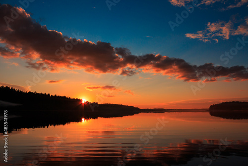 Bright orange and pink sunset on the lake in summer in Russia.