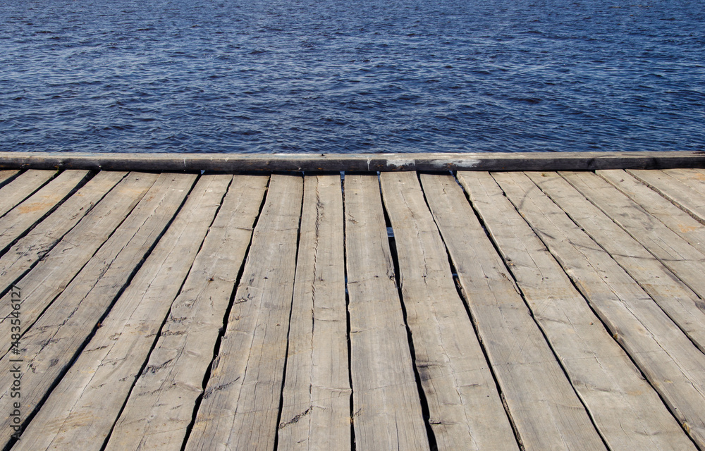 The line between a plank pier and water. Beautiful background.