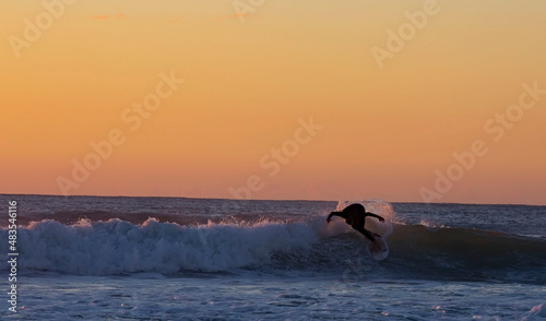 Fototapeta Naklejka Na Ścianę i Meble -  Riding the waves in Bali with surfing paradise and sunset sky scene background