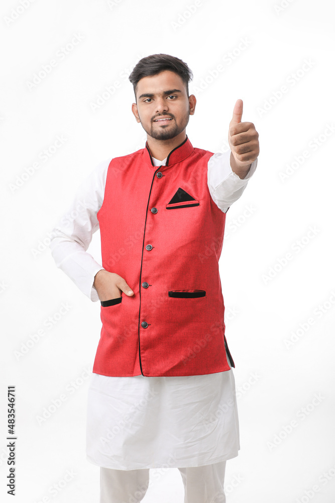 young indian man in traditional wear and showing thumps up on white background. young indian man in traditional wear and showing thumps up on white background.