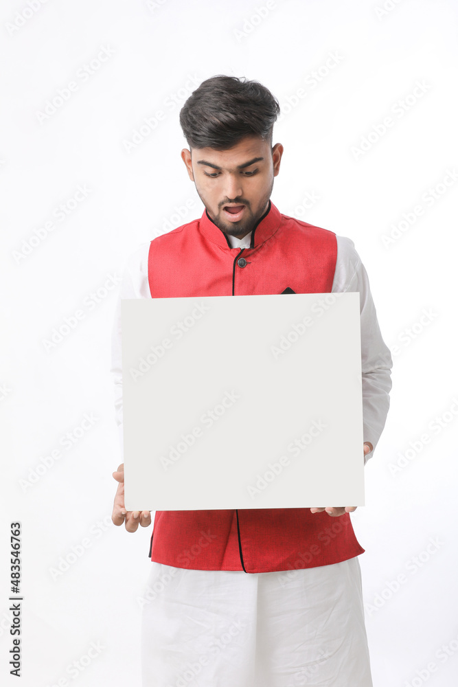 Indian man holding white board, promoting offers on festival season while wearing traditional cloths, standing over white background. Indian man holding white board, promoting offers on festival season while wearing traditional cloths, standing over white background.