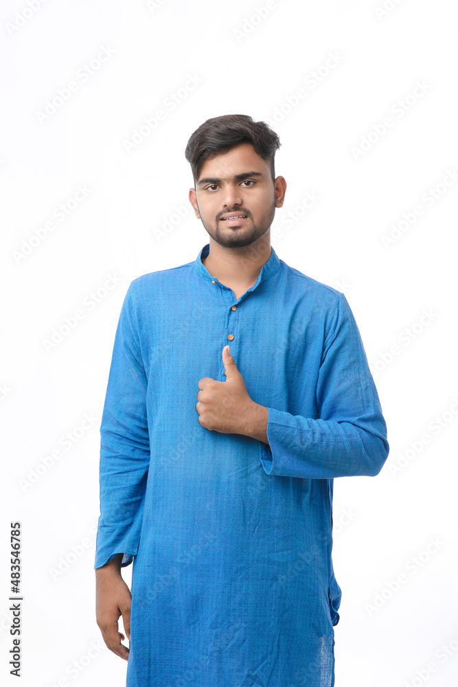 young indian man in traditional wear and showing thumps up on white background. young indian man in traditional wear and showing thumps up on white background.