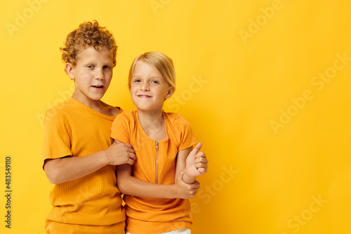 two joyful children cuddling fashion childhood entertainment on colored background unaltered