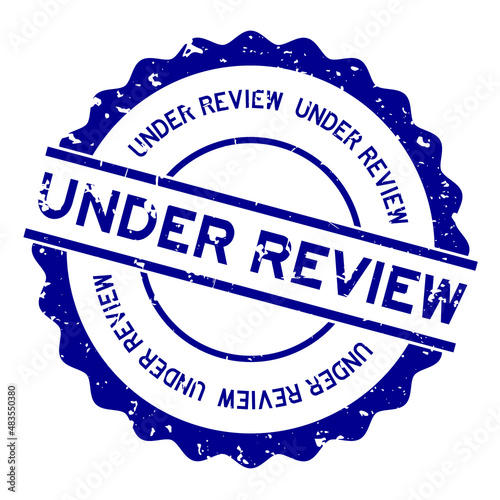 Grunge blue under review word round rubber seal stamp on white background