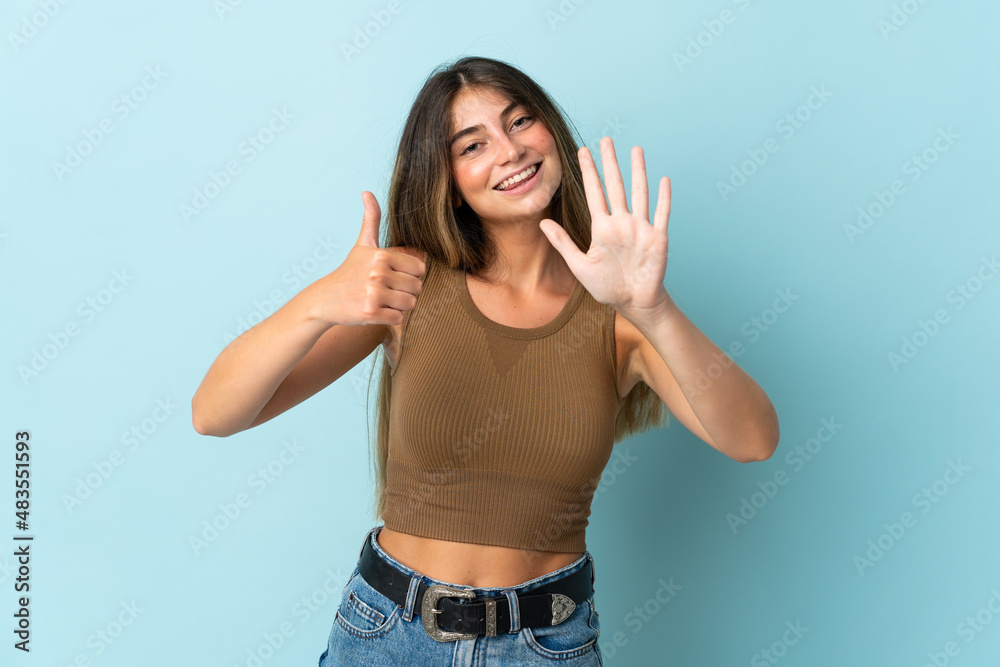 Young caucasian woman isolated on blue background counting six with fingers Young caucasian woman isolated on blue background counting six with fingers