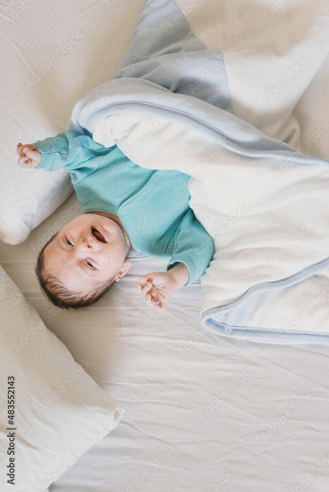 Little one month baby boy crying in the bed. Alone and defenseless Little one month baby boy crying in the bed. Alone and defenseless