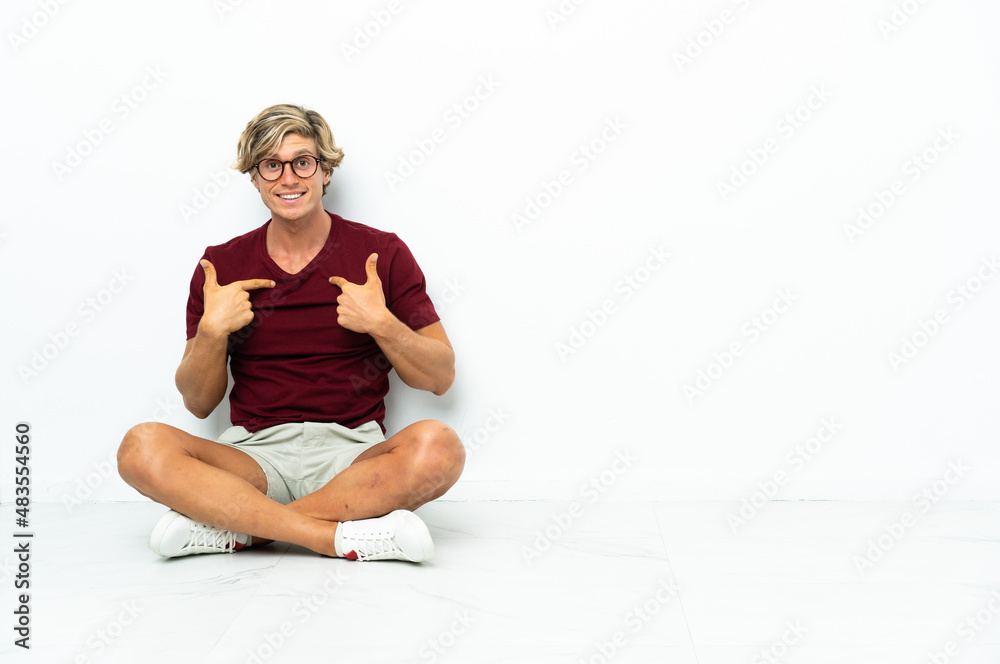 Fototapeta premium Young English man sitting on the floor with surprise facial expression