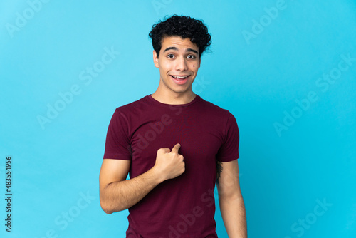 Young Venezuelan man isolated on blue background with surprise facial expression