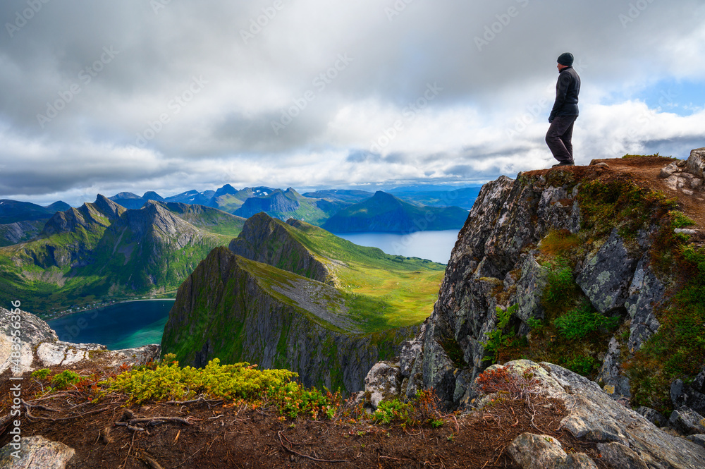 Hiker standing on the Husfjellet Mountain on Senja Island in northern Norway