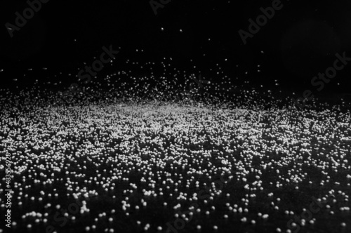Rice grains fall on a black surface on a black background