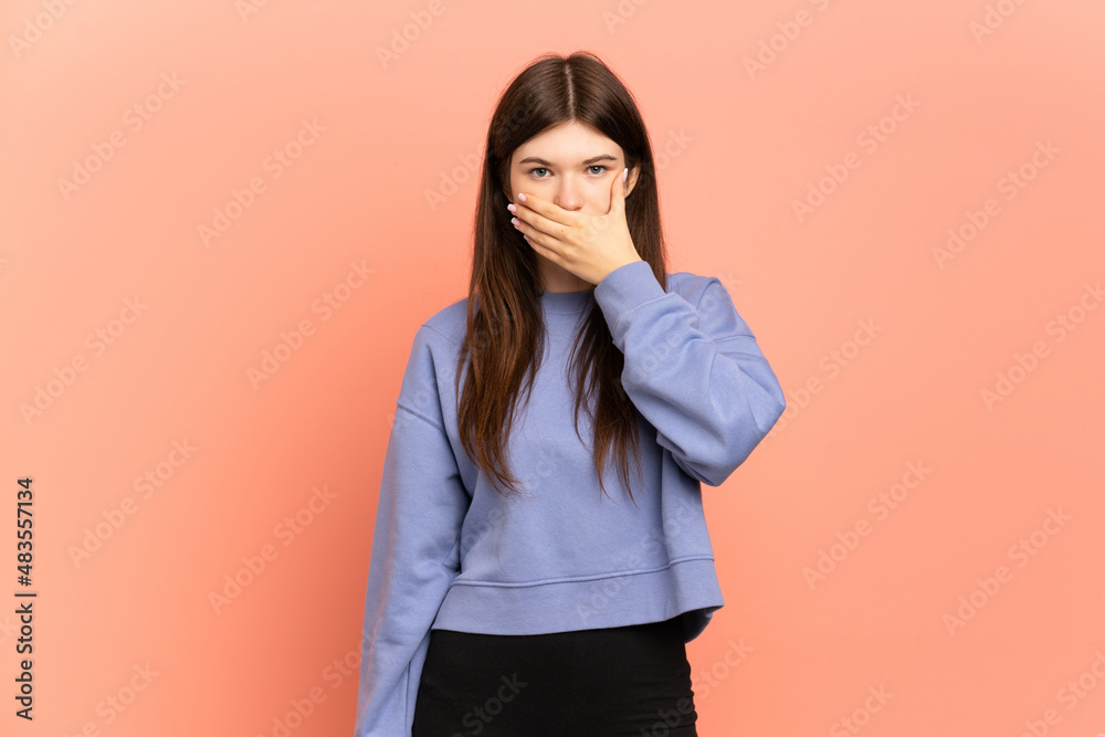 Young Ukrainian girl isolated on pink background covering mouth with hand Young Ukrainian girl isolated on pink background covering mouth with hand