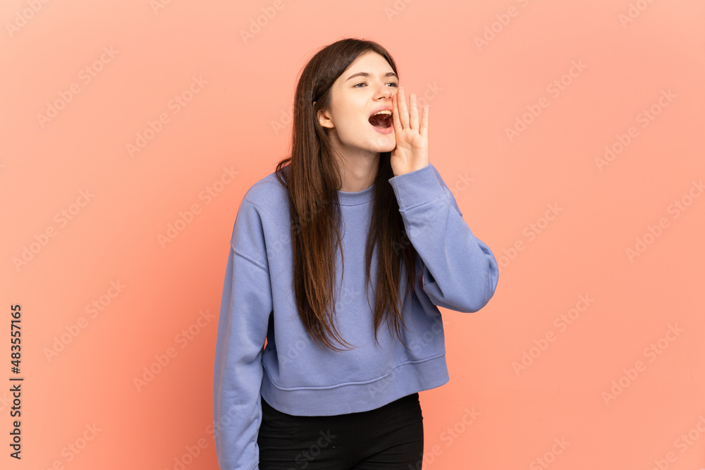 Young Ukrainian girl isolated on pink background shouting with mouth wide open to the side Young Ukrainian girl isolated on pink background shouting with mouth wide open to the side