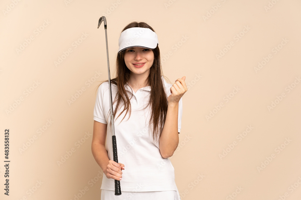Young Ukrainian golfer girl isolated on beige background making money gesture Young Ukrainian golfer girl isolated on beige background making money gesture