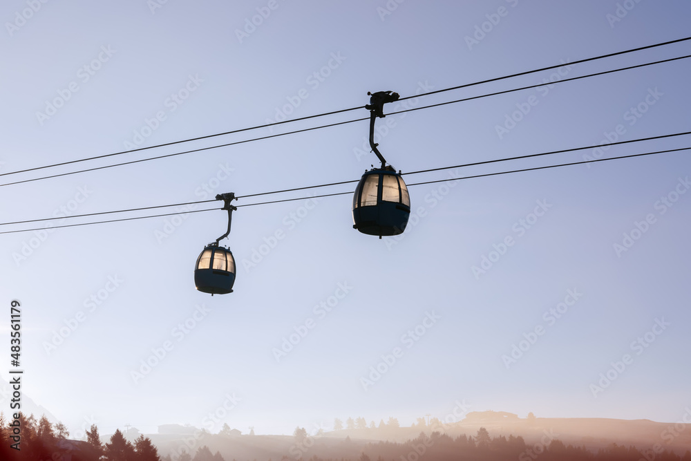 Cable car cabins above Seiser Alm plateau covered in morning mist. South Tyrol, Italy. Cable car cabins above Seiser Alm plateau covered in morning mist. South Tyrol, Italy.