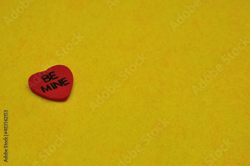 Be mine on a red heart isolated on a yellow background