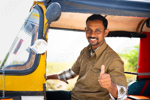 Foto Auto rickshaw driver showing thumbs up while on auto - concept of approval to ri