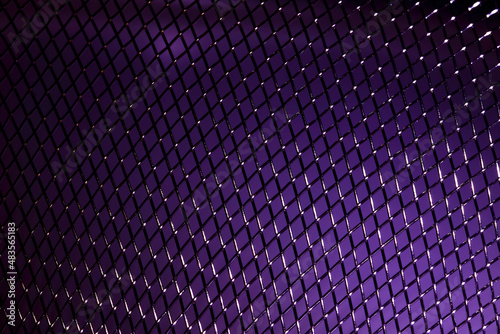 Macro close up view of a woven metalic stainless steel purple background