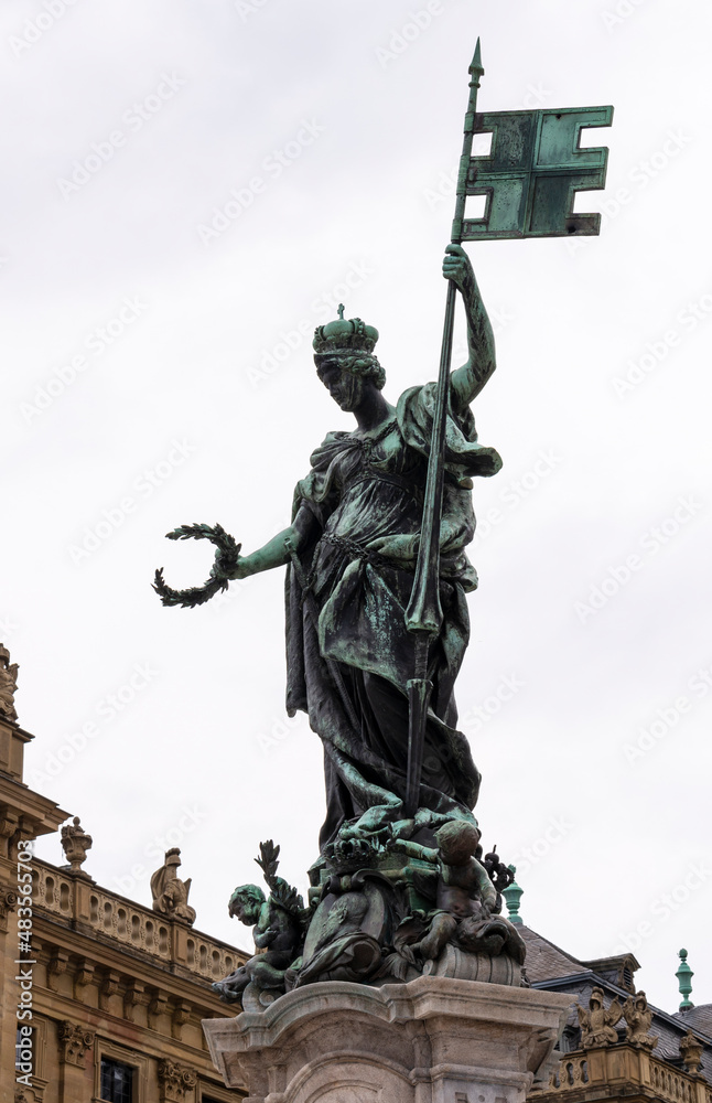 Würzburg's Franconia Fountain - green Statue with Bavarian flag and crown on the head on the cloudy sky background in summer day