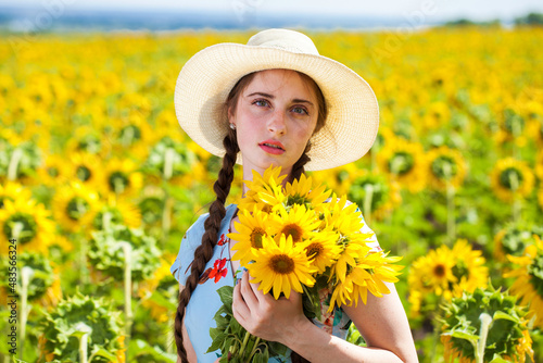 beautiful woman in a straw hat in a field of sunflowers