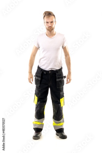 The Caucasian male in a white t-shirt and trousers stands on isolated white background. Worker and builder concept. 