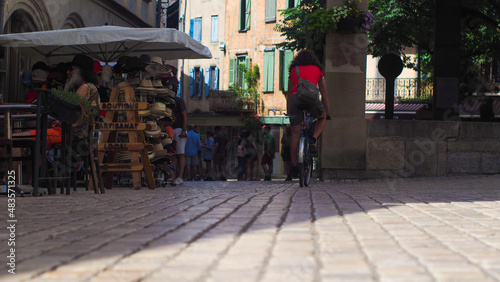 Personnes marchant dans la rue, dans une ville occitane, en période estivale