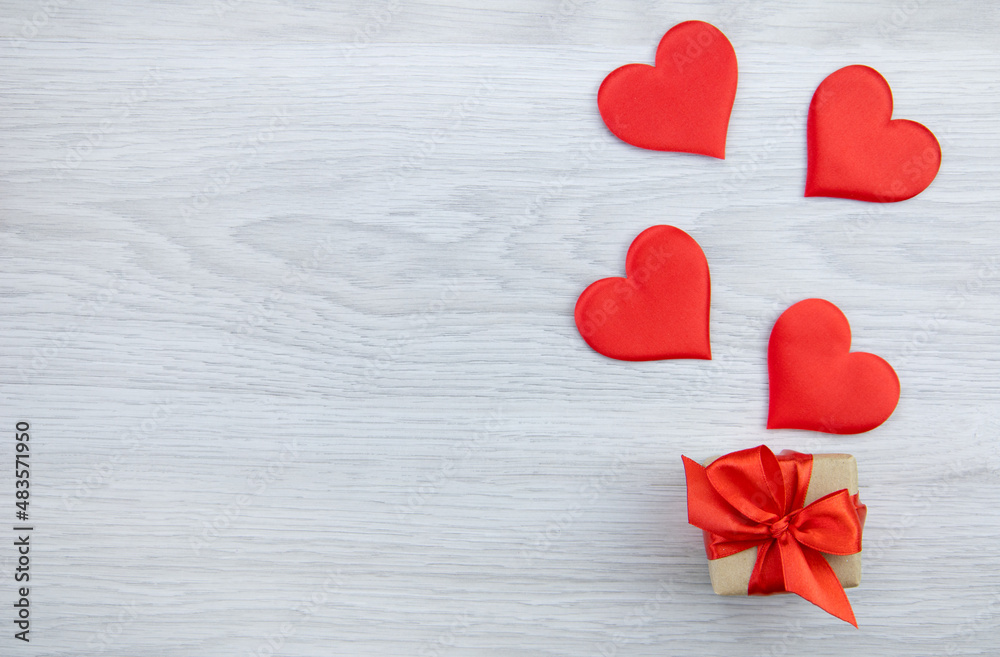 A box with a gift and hearts on a wooden background.The concept of love and celebration. Mother's Day, Valentine's Day, Birthday A box with a gift and hearts on a wooden background.The concept of love and celebration. Mother's Day, Valentine's Day, Birthday
