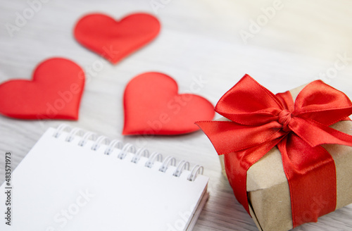 A gift, a notebook and hearts on the table.The concept of love and celebration.Valentine's day