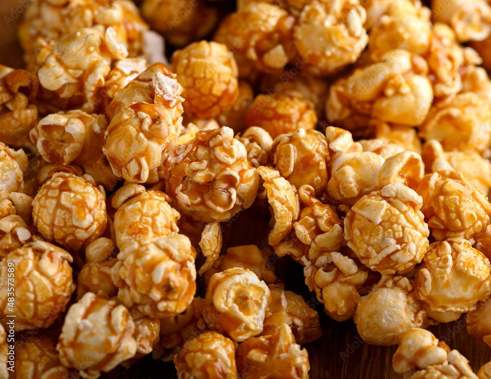 Delicious popcorn with caramel on wooden board Delicious popcorn with caramel on wooden board