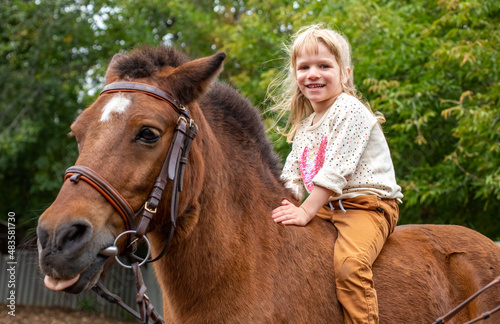 happy little girl riding a horse bareback