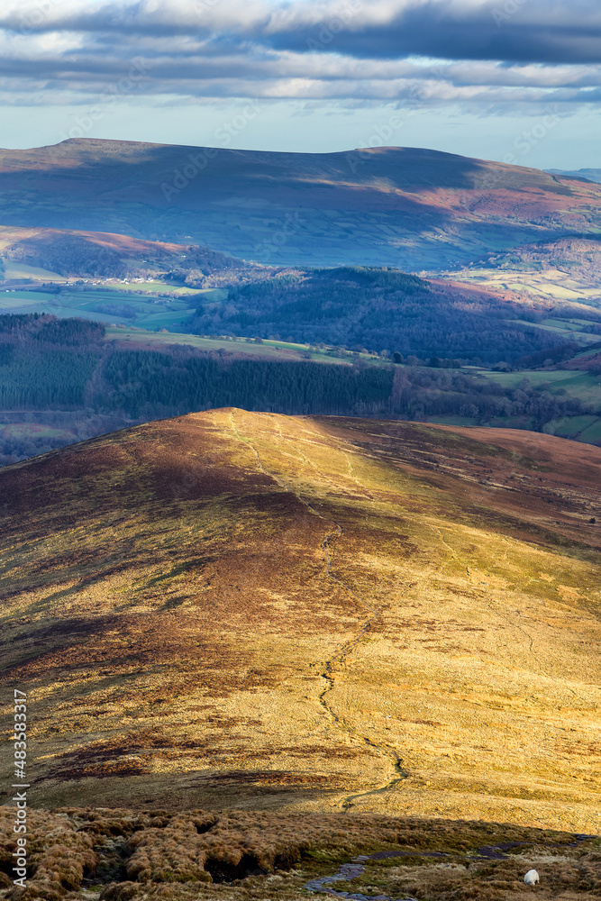 Late afternoon sunlight on the rural farmland and hills in the Brecon Beacons, Wales