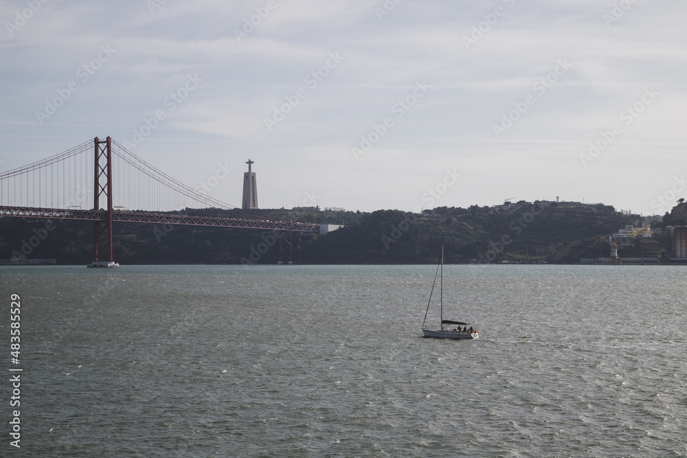 25 April Bridge and Sailing boat in Tejo river at Lisbon