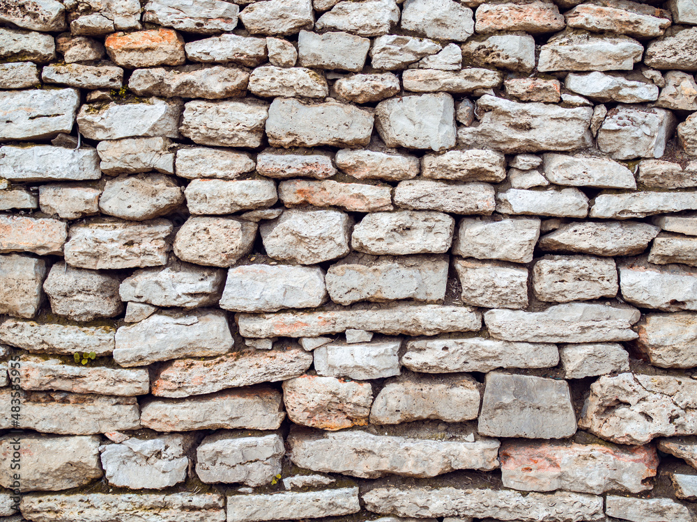 Old town's antic stone wall background. Front view texture