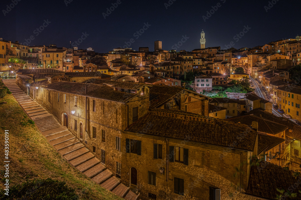 Torre del Mangia towering above the historic center of Siena at night, Tuscany, Italy