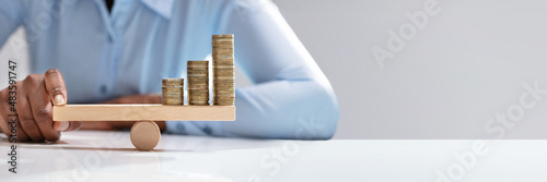 Tela Businesswoman Balancing Stacked Coins With Finger
