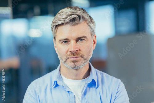 Portrait of senior experienced businessman, man thoughtfully looking at camera close up photo