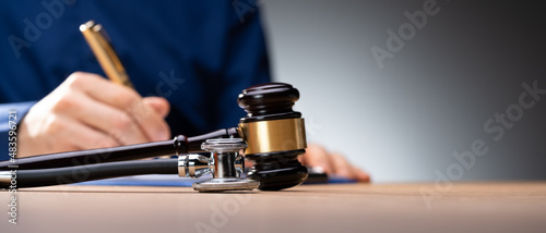 Foto Gavel With Medical Stethoscope On Wooden Desk