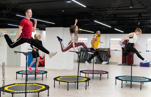 Women's and men's group on a sports trampoline, fitness training, healthy life - a concept trampoline group batut girl health, In the afternoon fit team in gym and young person, smiling happiness
