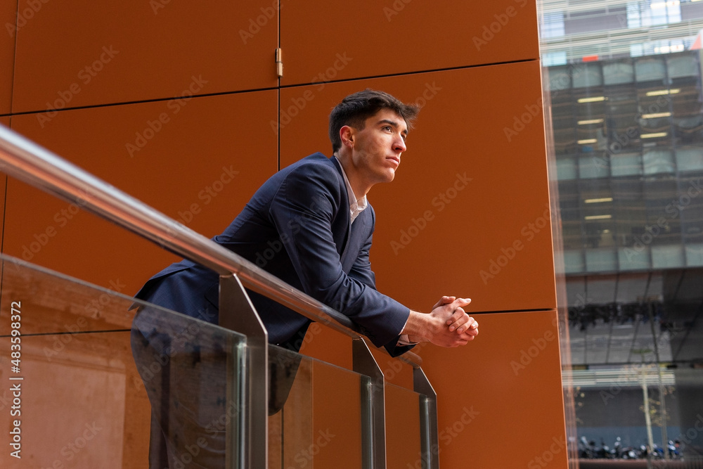 Portrait of a young entrepreneur looking at the city from a balcony. Young business man concept. Start up.