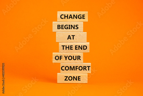 Out from comfort zone symbol. Wooden blocks with words Change begins at the end of your comfort zone. Beautiful orange table, orange background, copy space. Business, out from comfort zone concept. photo