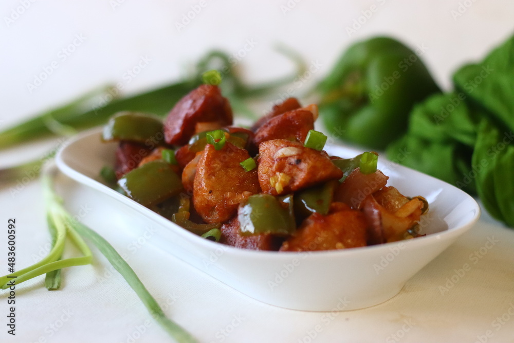 Idli Manchurian. An Indo Chinese fusion food made with leftover idlis, capsicum and spring onions. Prepared by cutting leftover idlis into small dumplings Idli Manchurian. An Indo Chinese fusion food made with leftover idlis, capsicum and spring onions. Prepared by cutting leftover idlis into small dumplings
