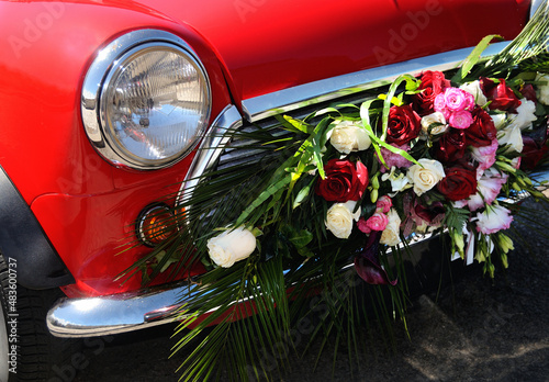 Frente de carro antigo vermelho decorado com flores para cerimónia de casamento